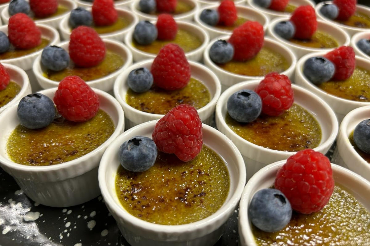 Kürbiskernöl Creme Brülee mit Himbeeren dekoriert